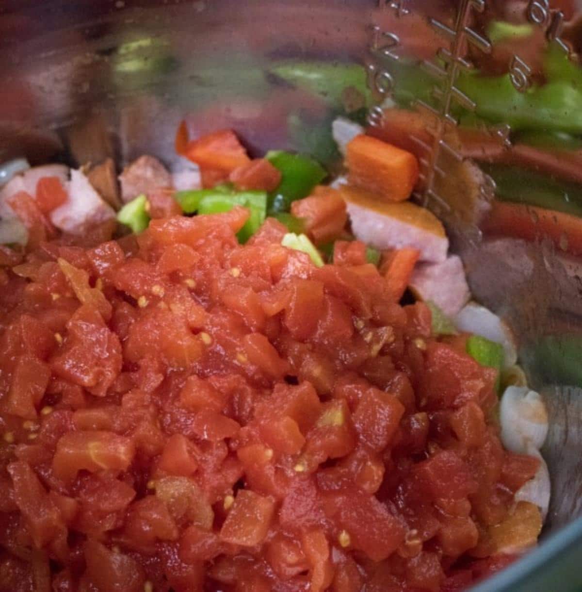Diced bell peppers, onions, sausage and tomatoes in an instant pot.