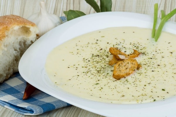 a bowl of cauliflower and cheese soup topped with croutons