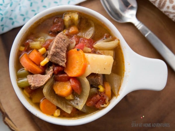 Spanish beef soup in a bowl on a table next to a spoon