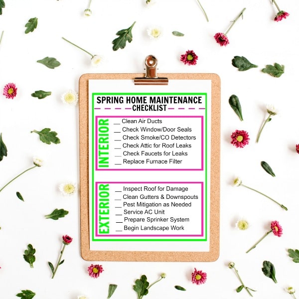 printable Spring Home Maintenance Checklist on a clipboard on a white background with flowers and leaves