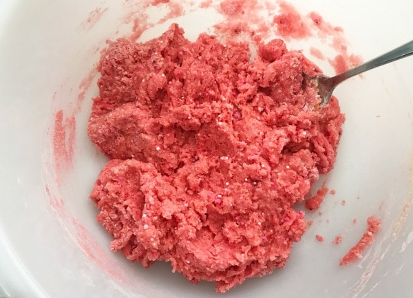 a utensil in the Strawberry Candy Heart Cookies batter in a white bowl