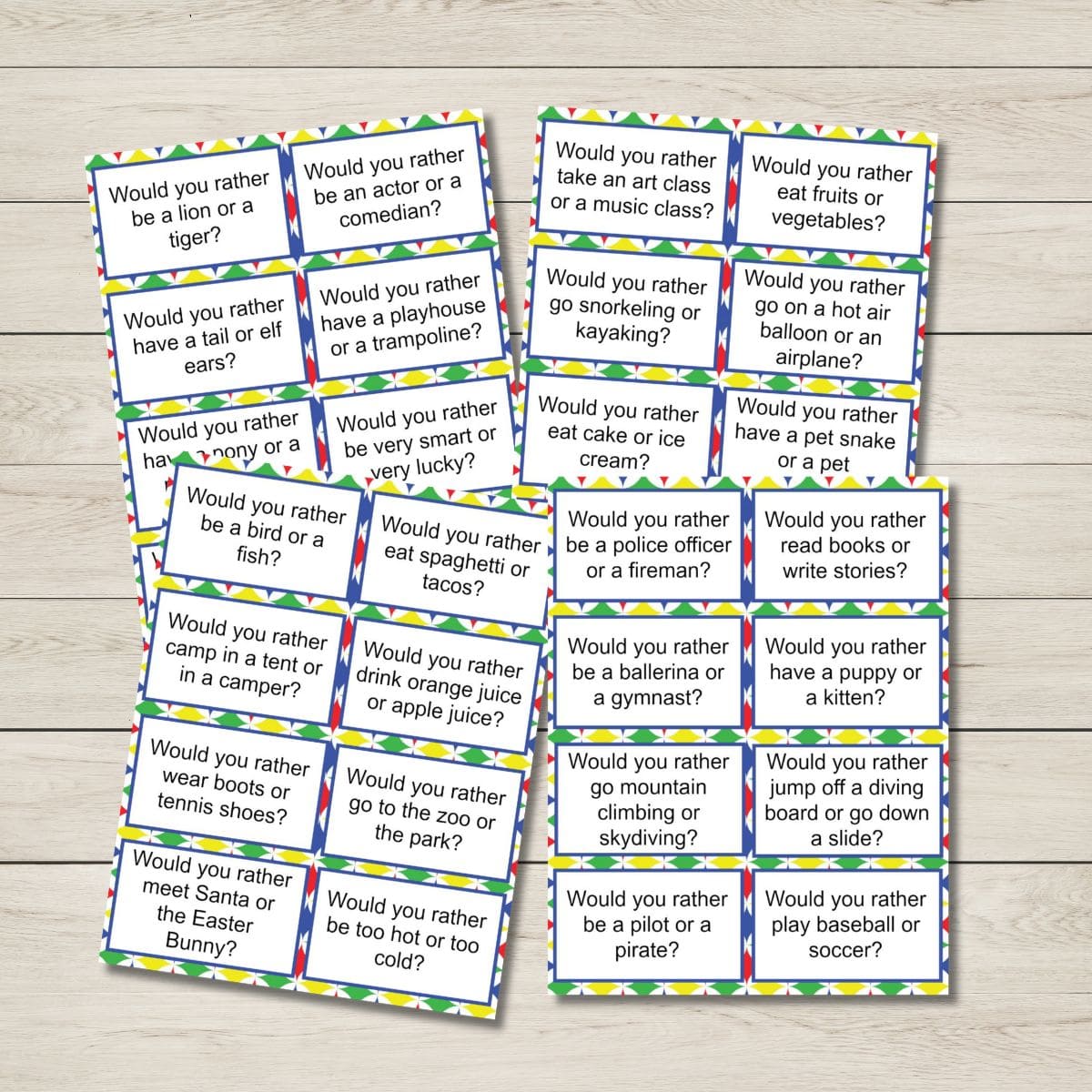 A set of cards on a wooden surface, each displaying a Would You Rather Questions for Kids—fun prompts covering animals, sports, food, holidays, and activities.