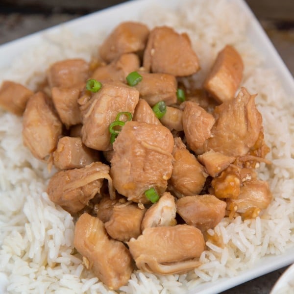 a plate of rice topped with orange chicken