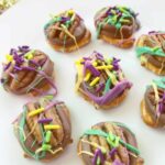 A plate of delightful Rolo Pretzel Bites topped with pecans, rich chocolate, and colorful sprinkles.