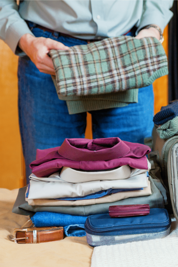 a man folding clothes to pack for a trip