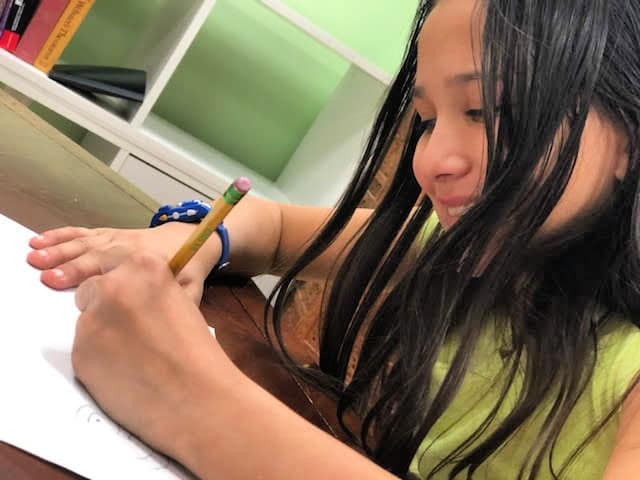 a girl drawing with a pencil