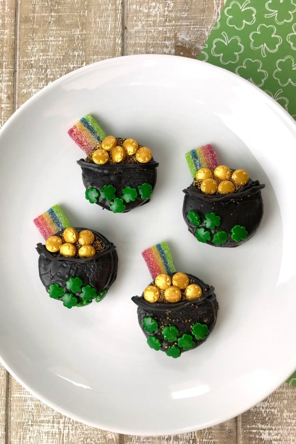 Oreo St. Patrick's Day Treats on a white plate on a wood table next to a green cloth