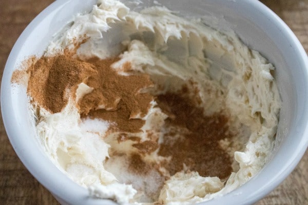 cream cheese, sugar and cinnamon in a white mixing bowl