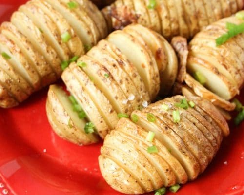 Hasselback Potatoes on red plate