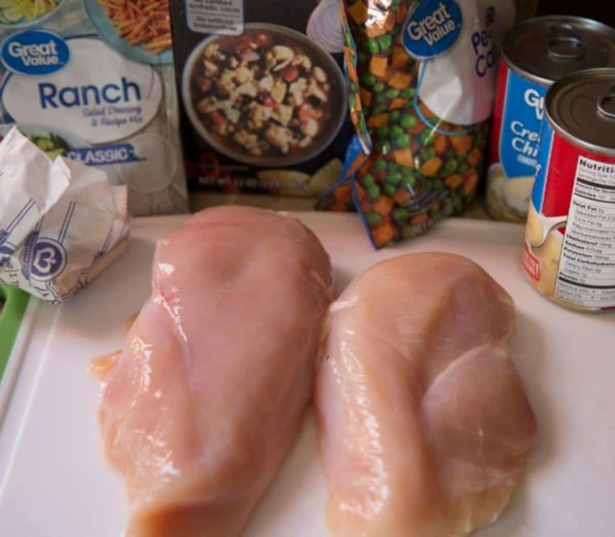 Raw chicken breasts, butter, ranch seasoning, broth, peas & carrots, and cream of chicken soup.