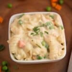 A creamy bowl of pasta with peas, carrots, and instant pot cooked chicken.