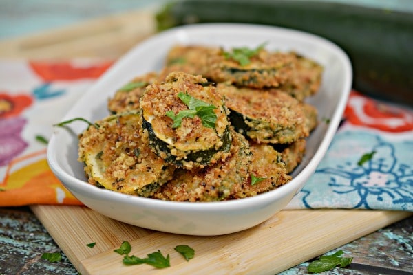 Keto Parmesan Zucchini Chips in a white baking dish on a flower linen