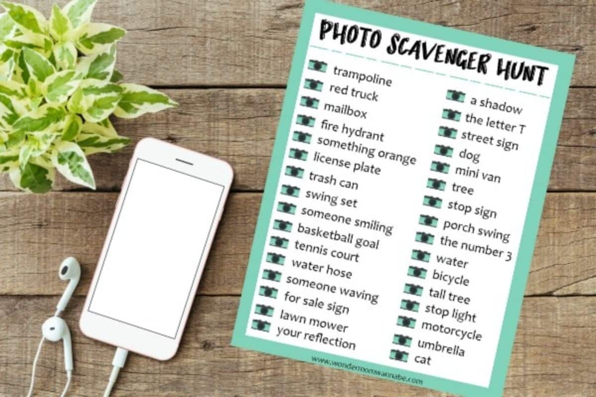 Printable Photo Scavenger Hunt next to a cell phone and headphones on a wood background.