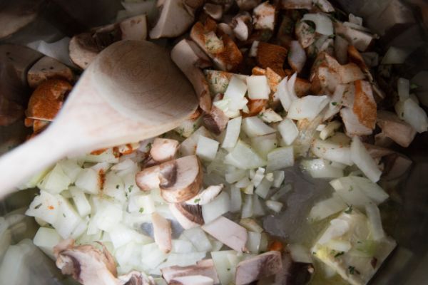 chopped onions, mushrooms, garlic, seasonings and a wooden spoon in an instant pot