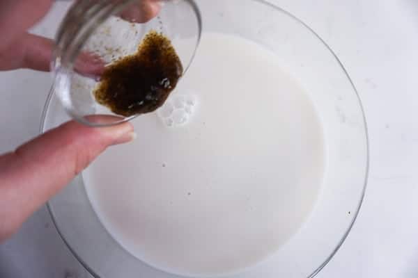 vanilla bean paste being added to milk to make a dragon frappuccino