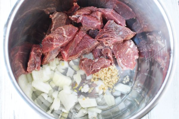 oil, garlic, steak and onions in an instant pot