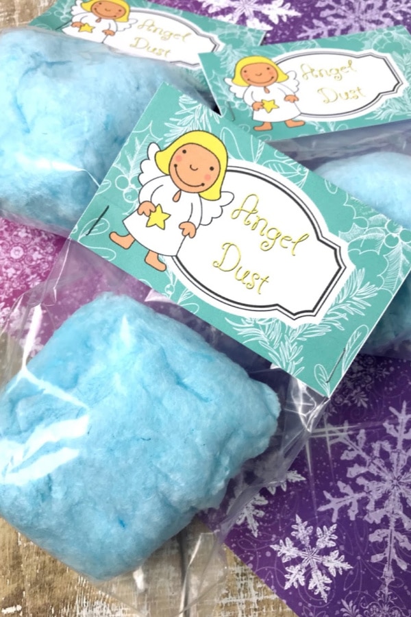 blue cotton candy in plastic bags with the label Angel Dust on a blue and pink linen on a brown table