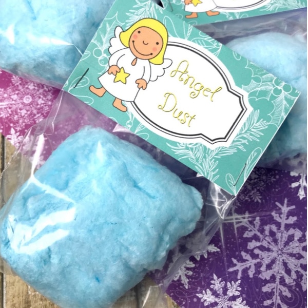 blue cotton candy in plastic bags with the label Angel Dust on a blue and pink linen on a brown table