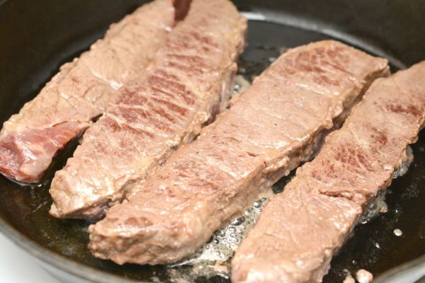 ribs cooking in oil in a frying pan