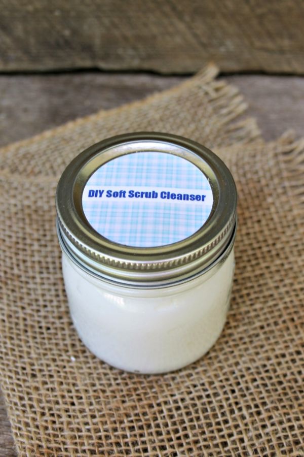 a glass jar with the label DIY Soft Scrub Cleanser on a burlap cloth on a table