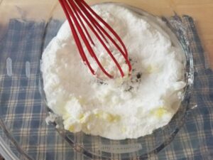 mixing up DIY bathroom cleaner in a bowl with a whisk
