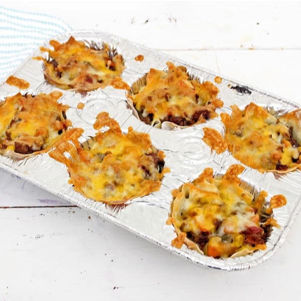 taco sausage cups in a muffin tin on a white table