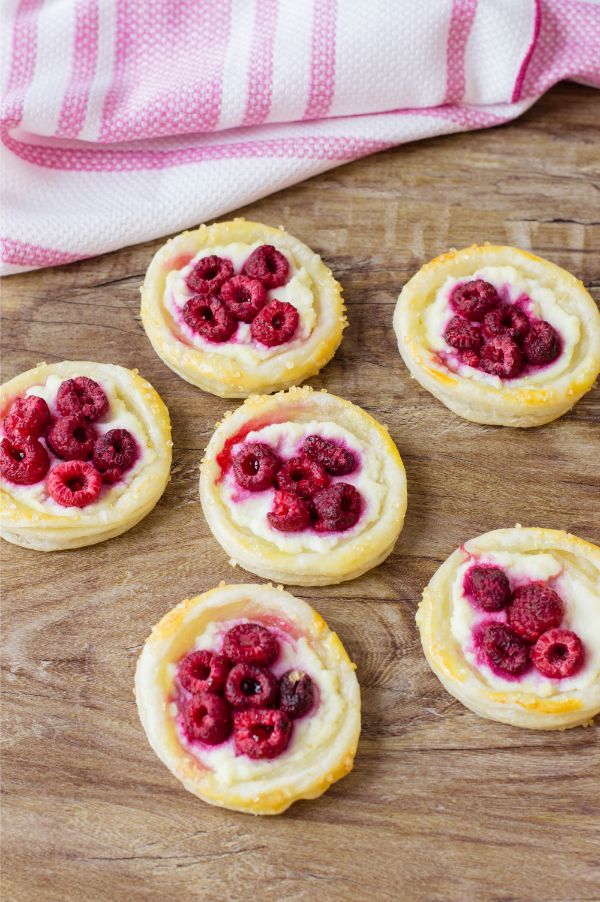 mini raspberry tarts on table with red and white cloth