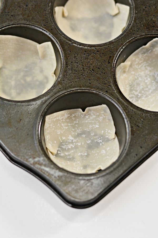 wonton wrappers in the bottom of a muffin tin