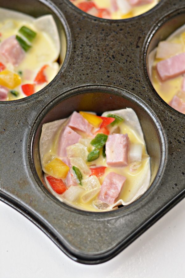 wonton wrappers, ham and veggies, eggs in a muffin tin