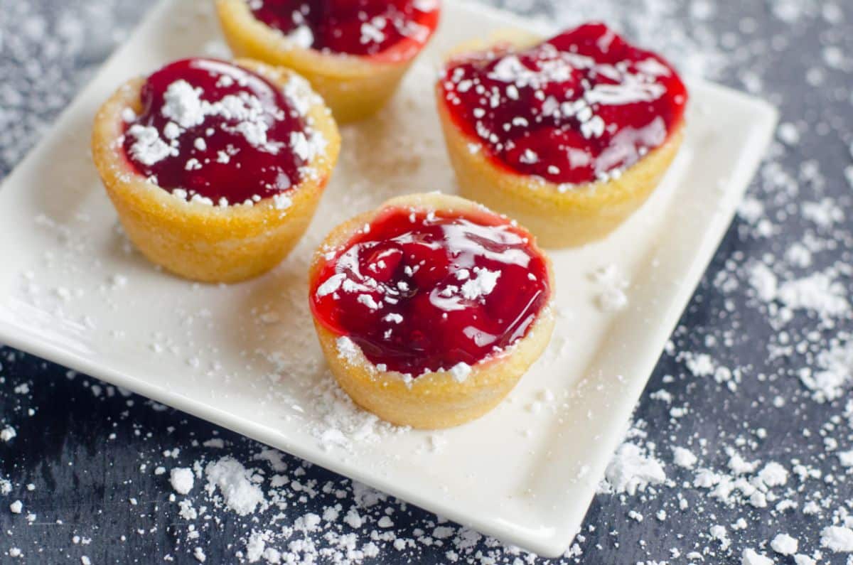 Cherry Pie Cookie Cups on a serving plate topped with powdered sugar.