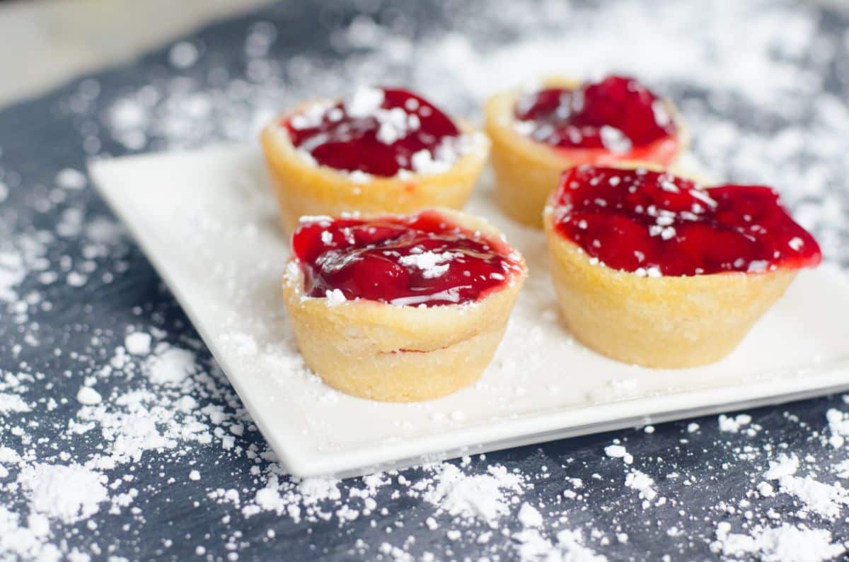 Cherry Pie Cookie Cups on a serving plate topped with powdered sugar.