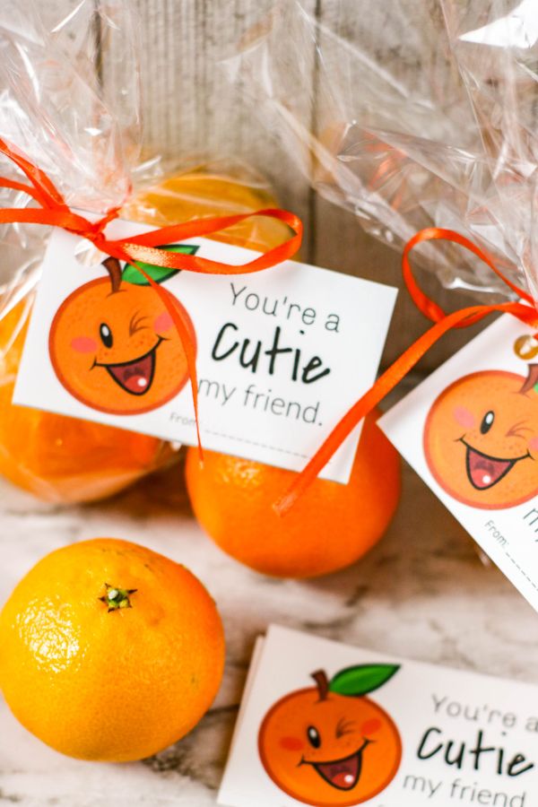treat bags filled with cutie oranges with "You're a Cutie" gift tag attached with orange curling ribbon with more gift tags and oranges on the counter