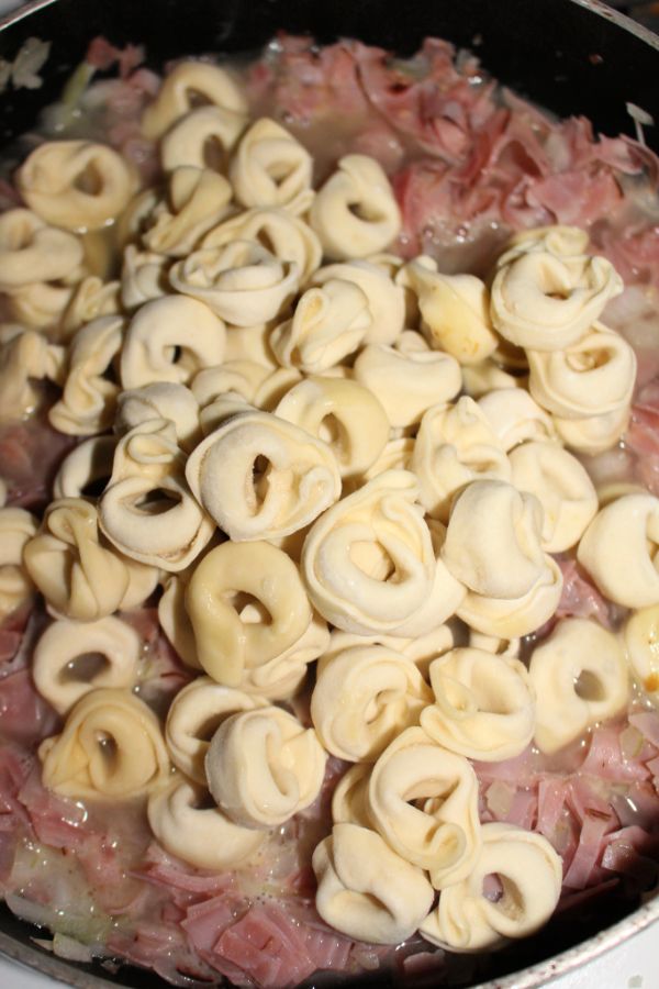 melted butter, ham, minced garlic, chicken broth, tortellini and diced onions in a skillet