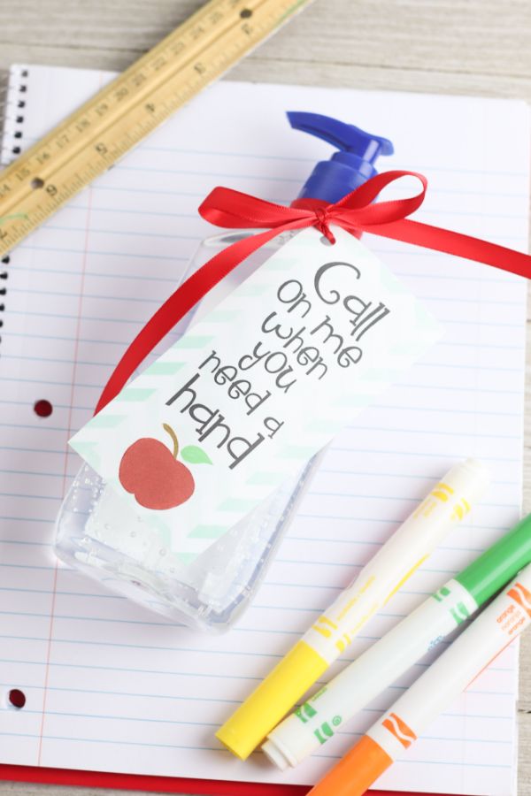 hand sanitizer teacher gift with printable with text reading call on me when you need a hand, on notebook paper next to markers and a ruler