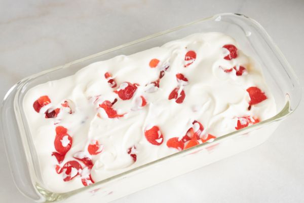 homemade candied cherry ice cream in a glass dish on a white counter