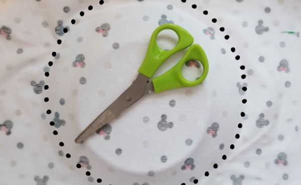 scissors on top of a cake plate on mickey mouse fabric