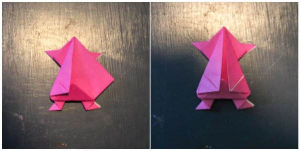 on a black background, the pink origami paper is folded to form a triangle.