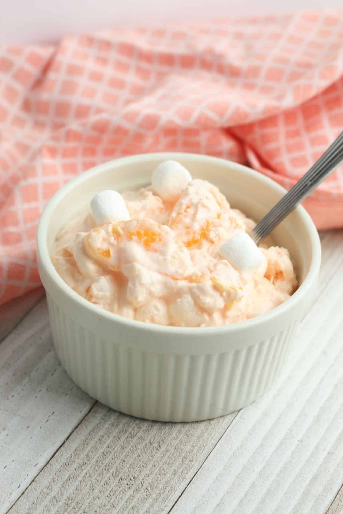 Weight Watchers Orange Fluff in a white serving bowl with a spoon in it.