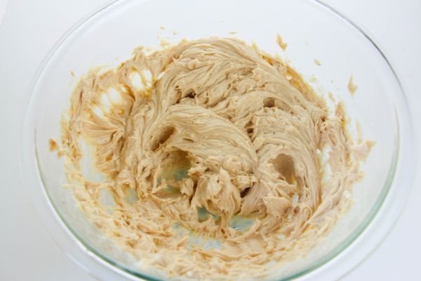 softened cream cheese, peanut butter and butter in a large glass bowl on a white table