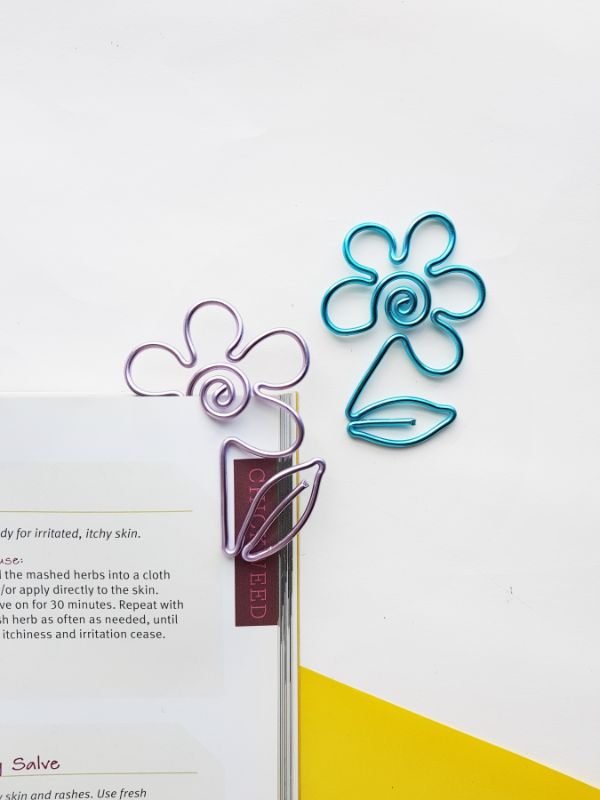 2 DIY wire flower bookmarks on a white background and clipped to some papers