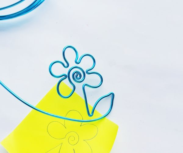 how to make a wire bookmark by bending the end to make a leaf, and a yellow printable flower template on a white background