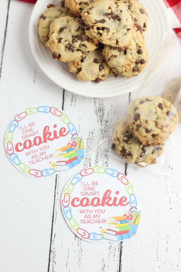 One Smart Cookie Teacher Gift with printable, cookies in a cellophane bag, and on a white plate, all on a wood table