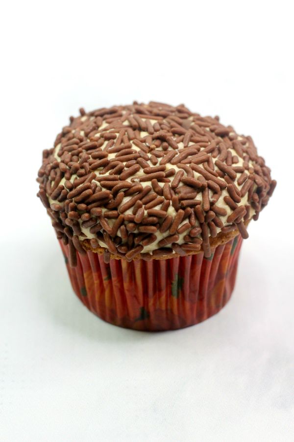 a pumpkin spice cupcake with buttercream frosting topped with chocolate sprinkles