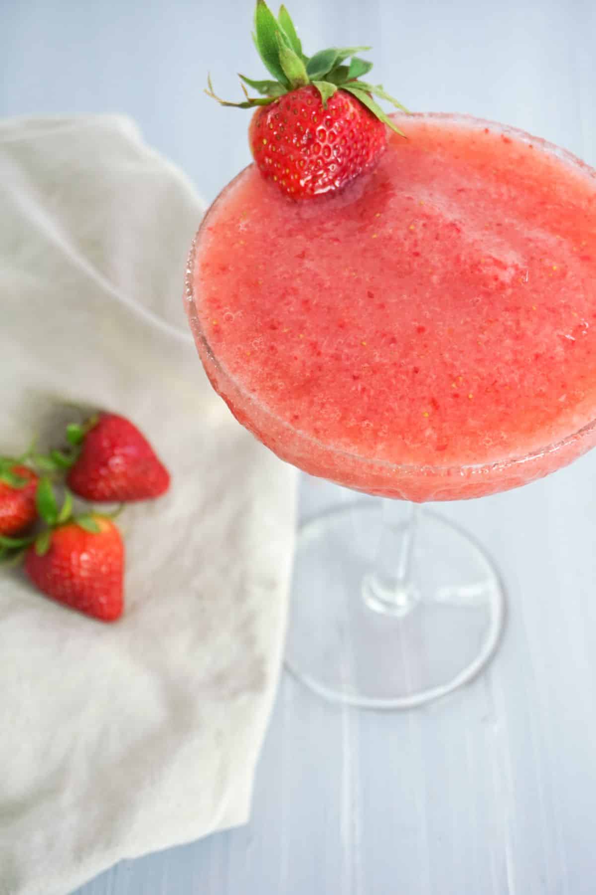 Strawberry Lemonade Margarita in a glass, garnished with strawberry.