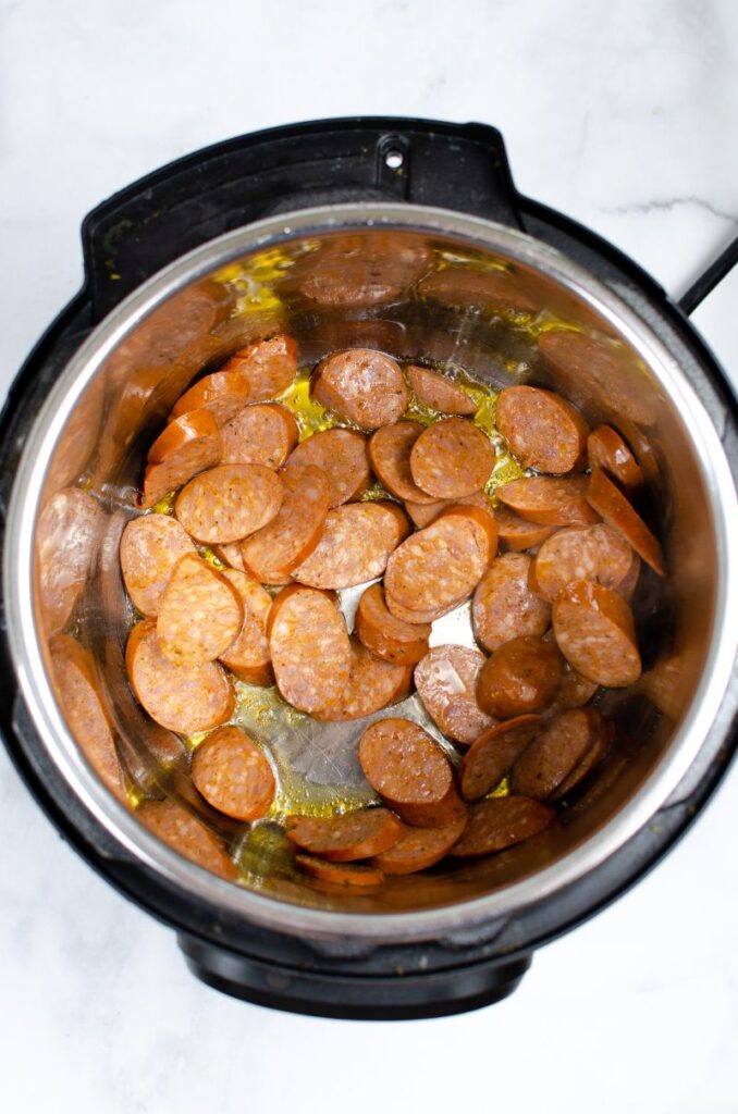 Chopped andouille sausages and oil in an instant pot.