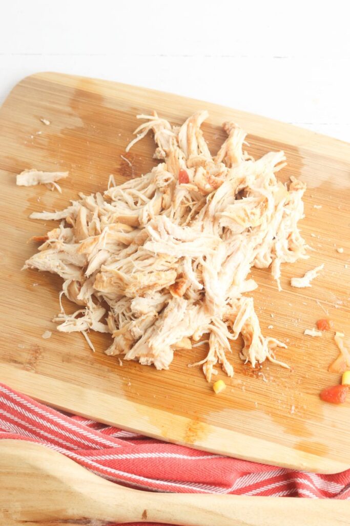 Shredded chicken on a cutting board.