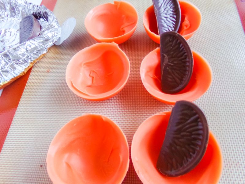filling the molds with an orange candy
