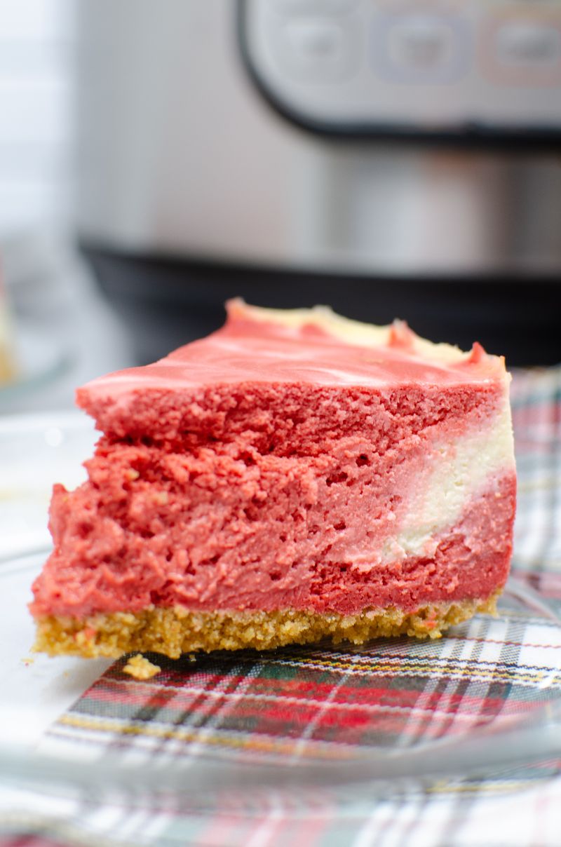 Perfect for Christmas dinner or Valentine's Day, this red velvet swirl cheesecake is easy to make in the instant pot. The sandy graham cracker crust and creamy cheesecake will satisfy your sweettooth! #cheesecake #redvelvetcheesecake #instantpotcheesecake #swirlcheesecake #easycheesecakerecipe #instantpotcheesecake #instantpotdessert #homemadedessert #homemadecheesecake  via @wondermomwannab