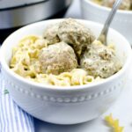 Swedish meatballs and pasta in a white bowl in front of an instant pot.