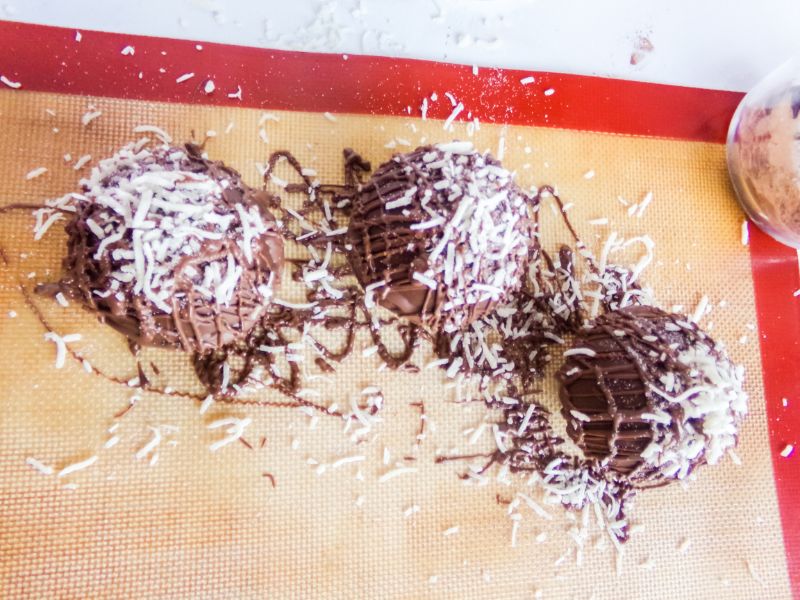 hot cocoa bombs topped with melted chocolate and shredded coconut